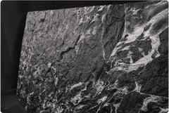  Veined Black Basalt flexible stone veneer – full sheet angled view showing flexibility with dramatic silver-white vein network on deep black textured surface, black background