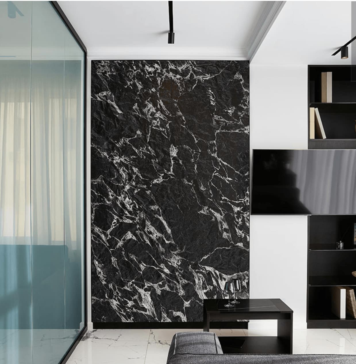 Veined Black Basalt flexible stone veneer on full-height living room feature wall – dramatic black and silver vein pattern paired with black shelving unit, track lighting and marble floor